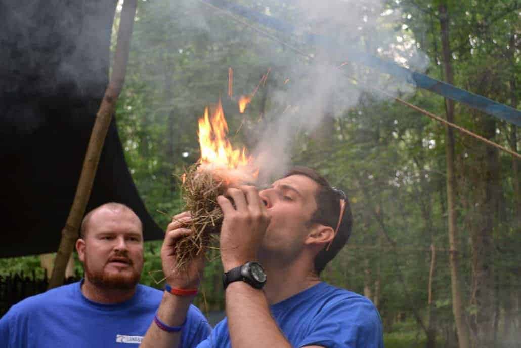 Wildway Bushcraft Owner John blowing an ember into fire